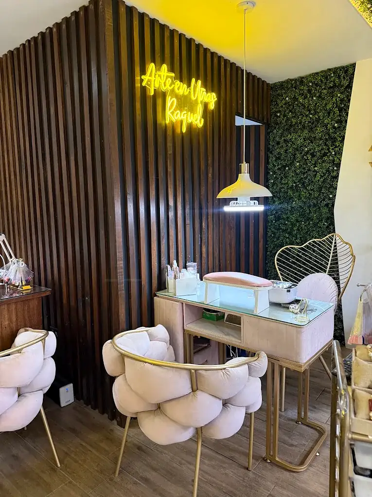 Mesa de manicure con sillas rosadas bajo el neón de Arte en Uñas Raquel